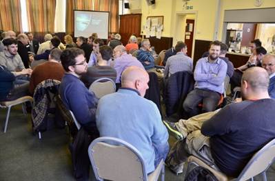 A group of people sitting in a room

Description automatically generated