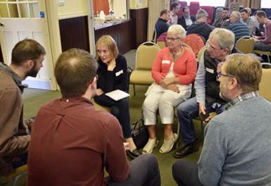 A group of people sitting in a circle

Description automatically generated